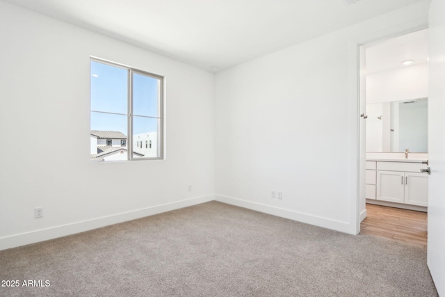10241 E Ursula Ave, Mesa, AZ 85212 - unfurnished bedroom featuring light carpet, baseboards, a sink, and ensuite bathroom