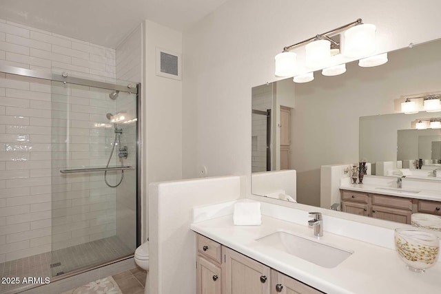 bathroom featuring toilet, an enclosed shower, and tile patterned floors