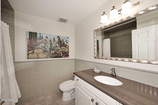 bathroom with toilet, vanity, and tile patterned floors