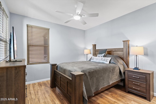 bedroom featuring ceiling fan, multiple windows, and light hardwood / wood-style flooring