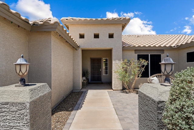 3658 E Pony Track Ln, San Tan Valley, AZ 85140 - view of exterior entry featuring stucco siding, a tiled roof, and a patio