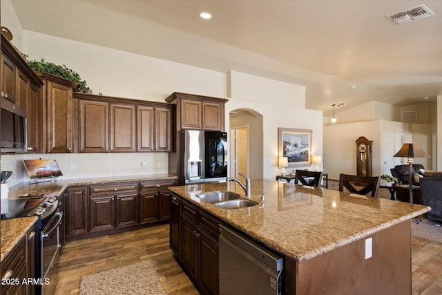 3658 E Pony Track Ln, San Tan Valley, AZ 85140 - kitchen featuring appliances with stainless steel finishes, a sink, arched walkways, dark wood-style floors, and recessed lighting