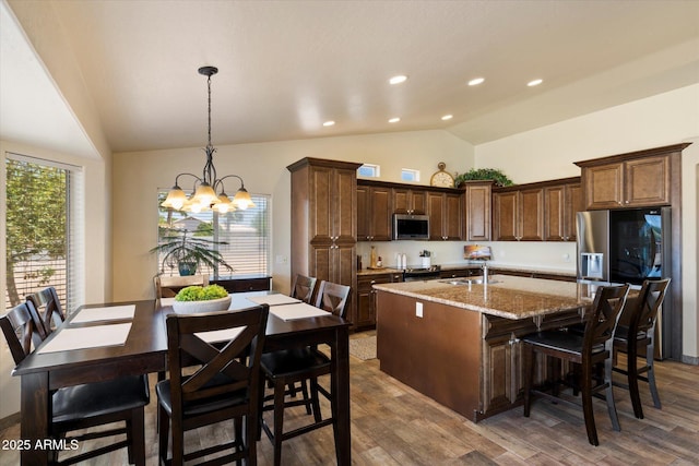 3658 E Pony Track Ln, San Tan Valley, AZ 85140 - kitchen with stainless steel microwave, a sink, an island with sink, a chandelier, and wood finished floors
