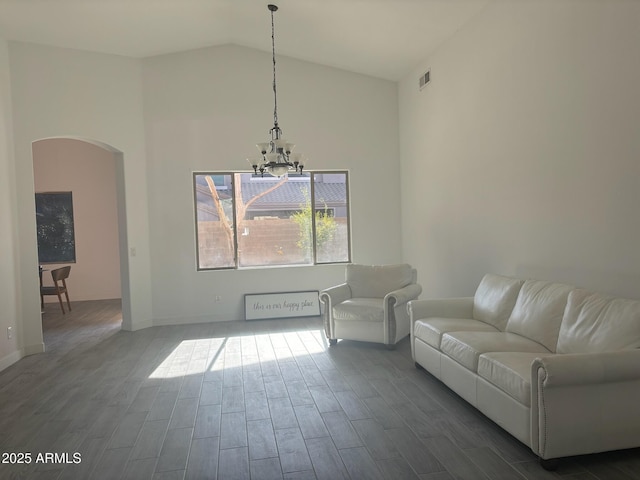 unfurnished living room featuring a chandelier and vaulted ceiling