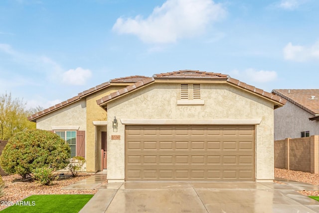5590 W Victory Way, Florence, AZ 85132 - mediterranean / spanish home with an attached garage, concrete driveway, stucco siding, and a tile roof