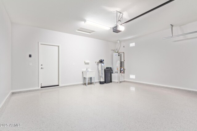 5590 W Victory Way, Florence, AZ 85132 - garage featuring a garage door opener, water heater, and baseboards