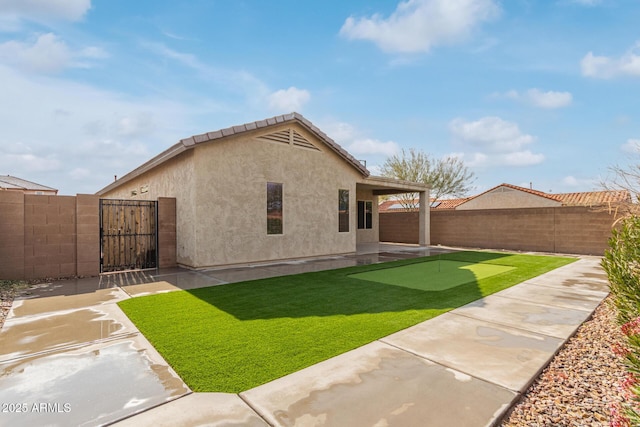 5590 W Victory Way, Florence, AZ 85132 - back of property with a putting area, a patio area, a gate, and stucco siding