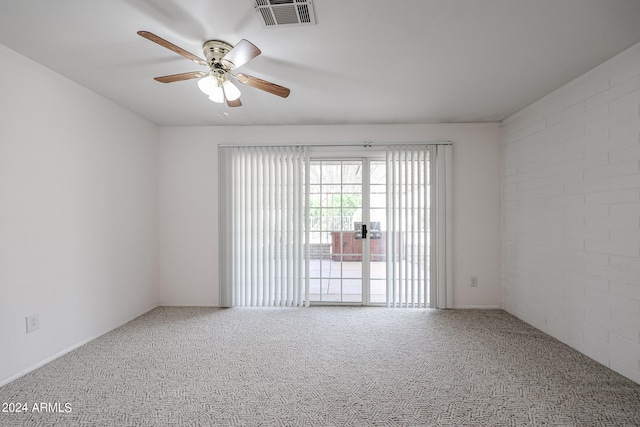 empty room with brick wall, ceiling fan, and carpet