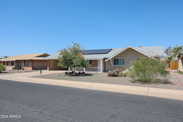 ranch-style home featuring solar panels and a garage