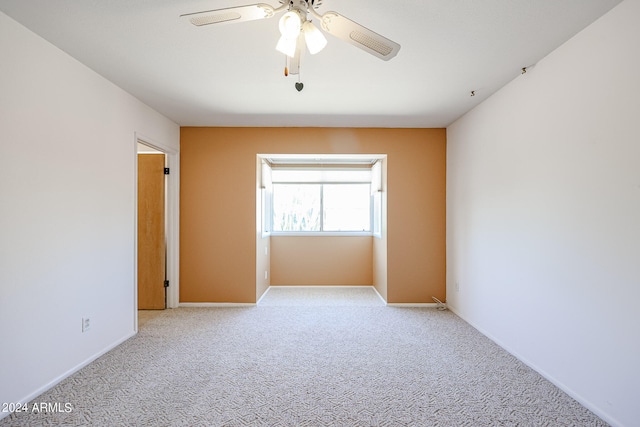 carpeted spare room with ceiling fan