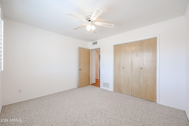 unfurnished bedroom with light carpet, ceiling fan, and a closet