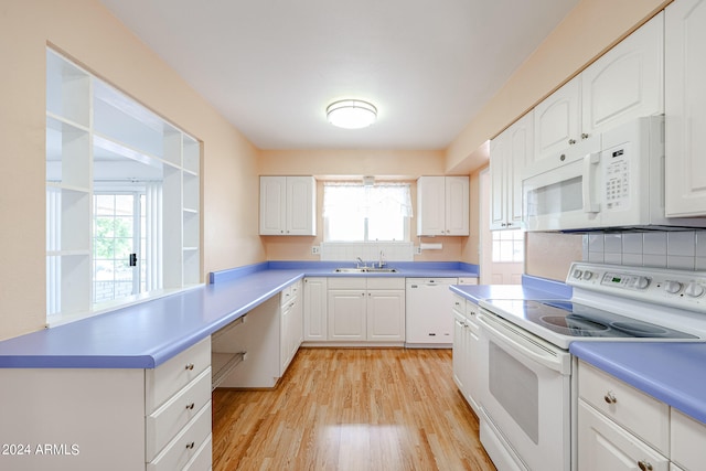 kitchen with white appliances, light hardwood / wood-style floors, sink, decorative backsplash, and white cabinets