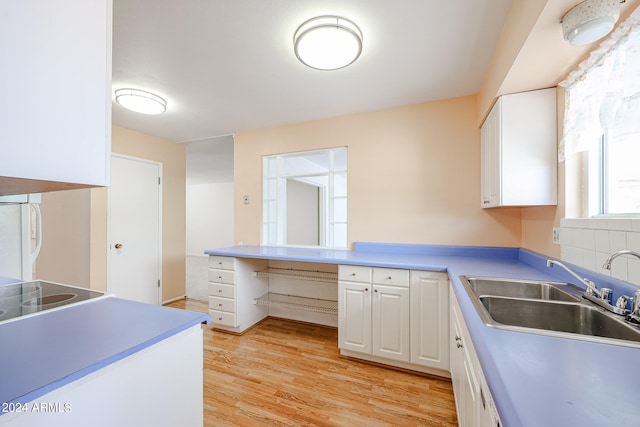 kitchen featuring white fridge, light hardwood / wood-style flooring, backsplash, sink, and white cabinets