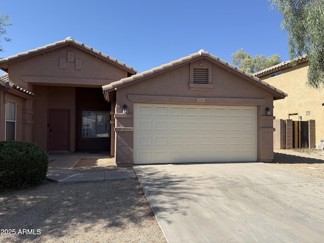 1930 W Burgess Ln, Phoenix, AZ 85041 - view of front of home featuring driveway, an attached garage, stucco siding, and a tile roof