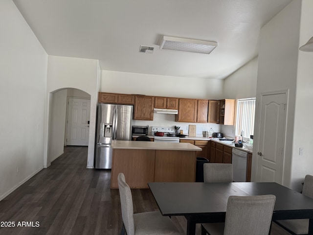 1930 W Burgess Ln, Phoenix, AZ 85041 - kitchen with white appliances, a kitchen island, under cabinet range hood, arched walkways, and dark wood-type flooring
