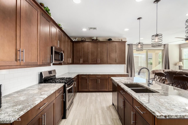 kitchen with ceiling fan, decorative backsplash, sink, and appliances with stainless steel finishes