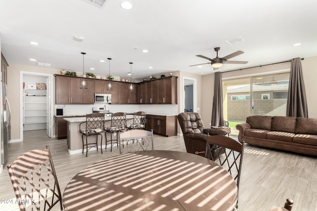 living room with ceiling fan and light hardwood / wood-style floors