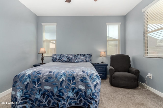 bedroom with light carpet, multiple windows, and ceiling fan