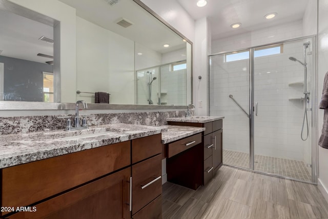 bathroom featuring plenty of natural light, vanity, a shower with shower door, and hardwood / wood-style flooring