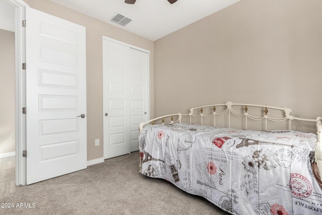 bedroom featuring light colored carpet, a closet, and ceiling fan