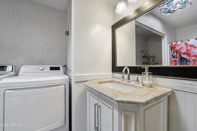 3551 N 12th St Unit 101, Phoenix, AZ 85014 - full bathroom featuring vanity, a textured wall, and washing machine and clothes dryer