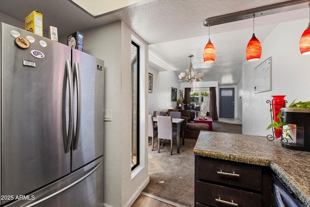 3551 N 12th St Unit 101, Phoenix, AZ 85014 - kitchen featuring freestanding refrigerator, a chandelier, a textured ceiling, wood finished floors, and decorative light fixtures