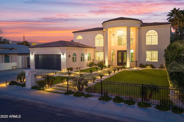 mediterranean / spanish-style house featuring a garage and a yard