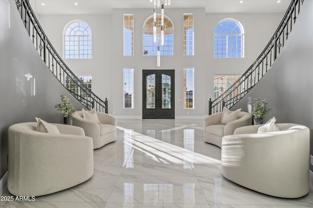 interior space with a chandelier, a wealth of natural light, and french doors