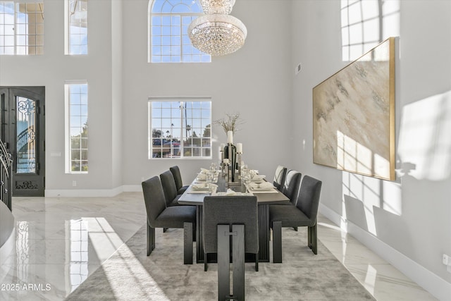 dining room with a towering ceiling and a chandelier