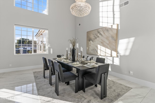 dining room with a high ceiling and a chandelier