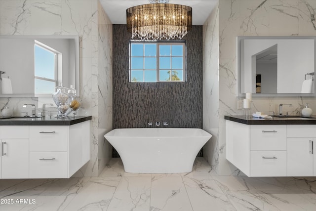 bathroom featuring a tub to relax in, vanity, and a notable chandelier