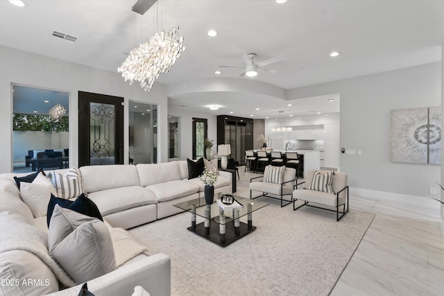 living room featuring ceiling fan with notable chandelier