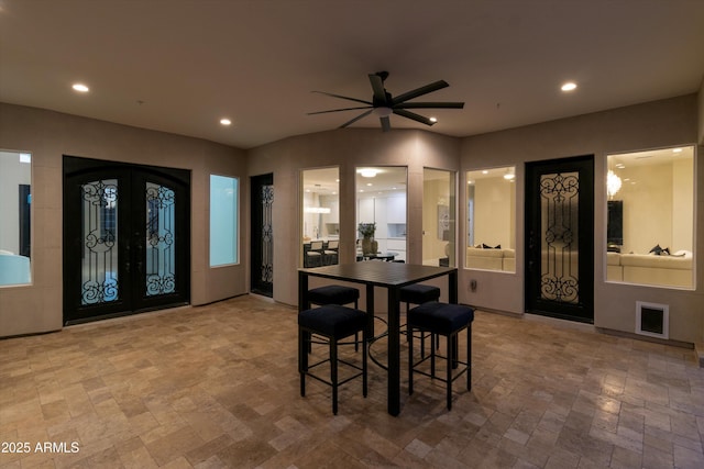 dining space featuring ceiling fan and french doors