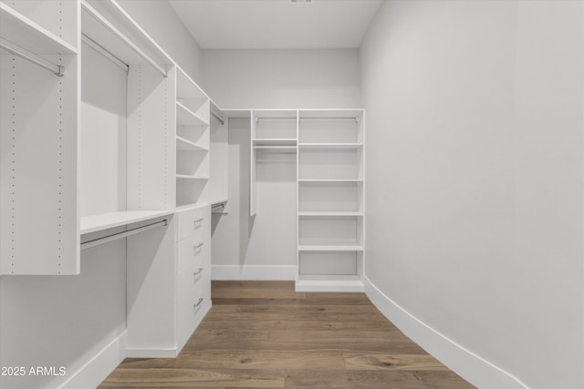 spacious closet with dark hardwood / wood-style flooring