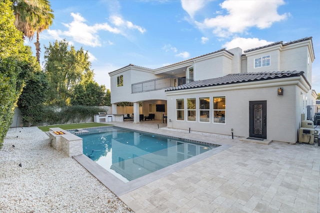 back of house featuring a balcony and a patio