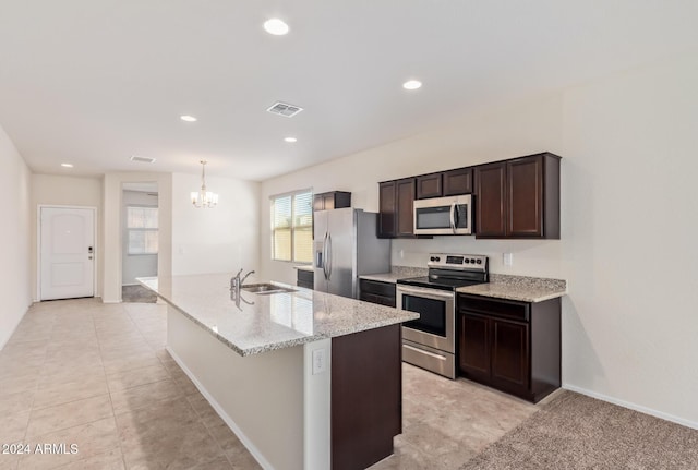 kitchen with a chandelier, decorative light fixtures, stainless steel appliances, an island with sink, and sink