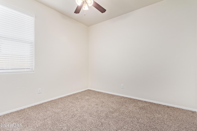 carpeted spare room featuring ceiling fan