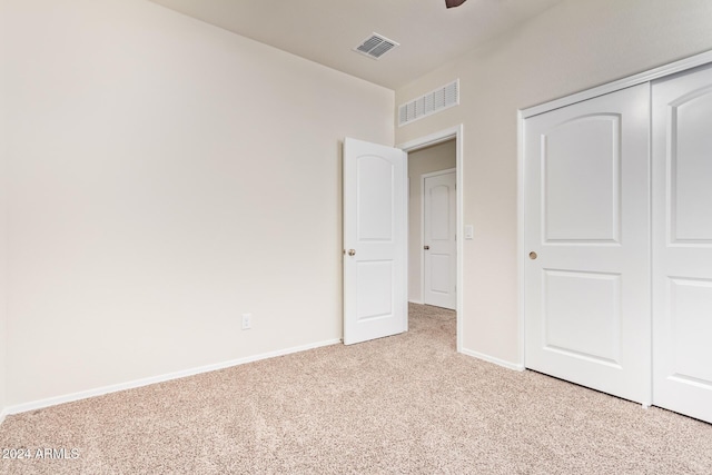 unfurnished bedroom with a closet and light carpet