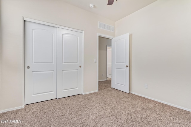 unfurnished bedroom with a closet, light carpet, and ceiling fan