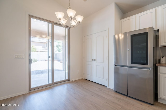 1956 N Hubbard Ln, Casa Grande, AZ 85122 - unfurnished dining area featuring an inviting chandelier, light wood-style floors, and baseboards