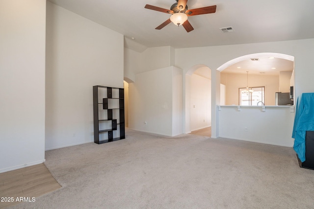 1956 N Hubbard Ln, Casa Grande, AZ 85122 - unfurnished room featuring ceiling fan, light colored carpet, arched walkways, baseboards, and visible vents