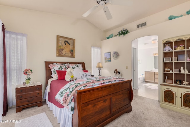 carpeted bedroom featuring ceiling fan, vaulted ceiling, and ensuite bathroom