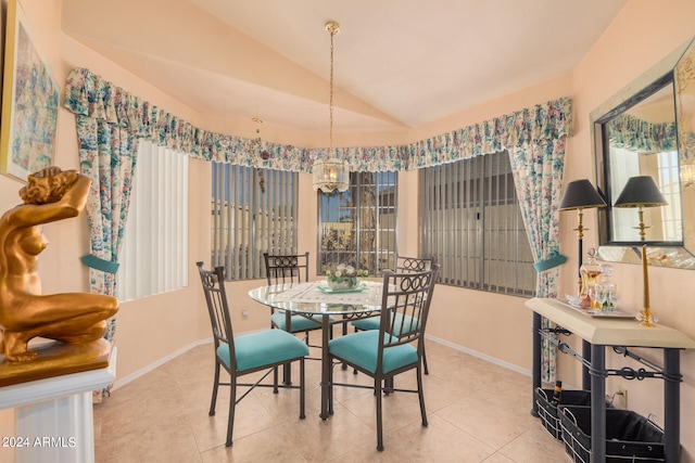 dining space with vaulted ceiling and light tile patterned flooring