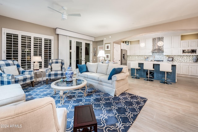 living room featuring ceiling fan and light wood-type flooring