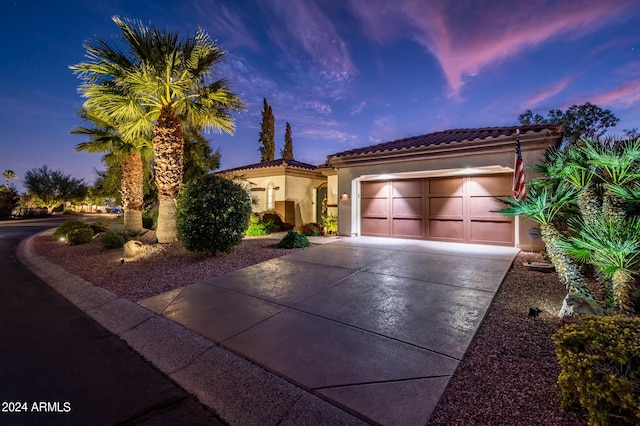 mediterranean / spanish home featuring a garage