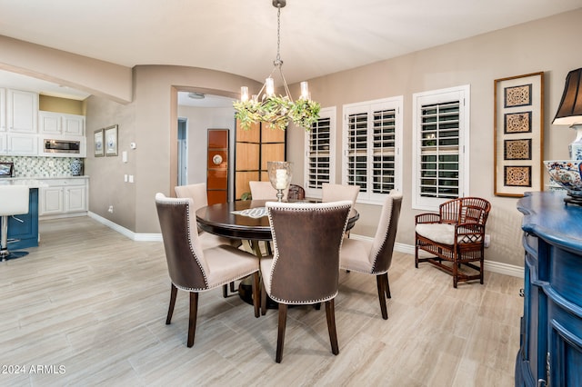 dining space featuring light hardwood / wood-style floors and a chandelier