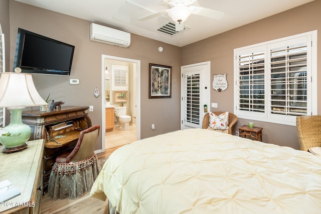 bedroom featuring connected bathroom, ceiling fan, light hardwood / wood-style floors, and a wall unit AC