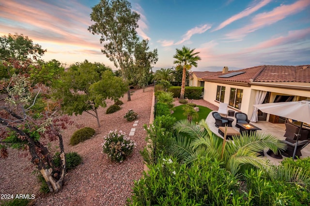 yard at dusk with a patio area