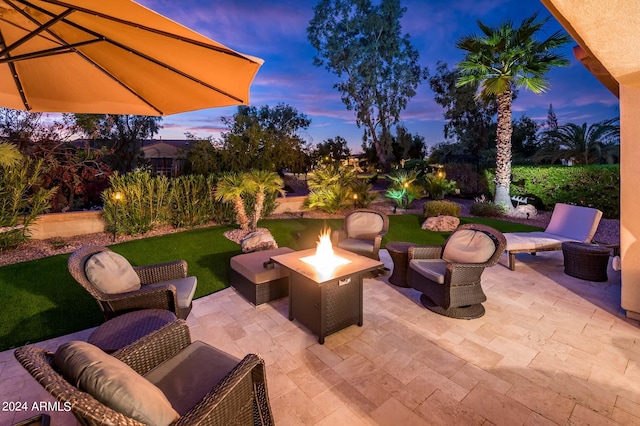 patio terrace at dusk with a yard and an outdoor fire pit