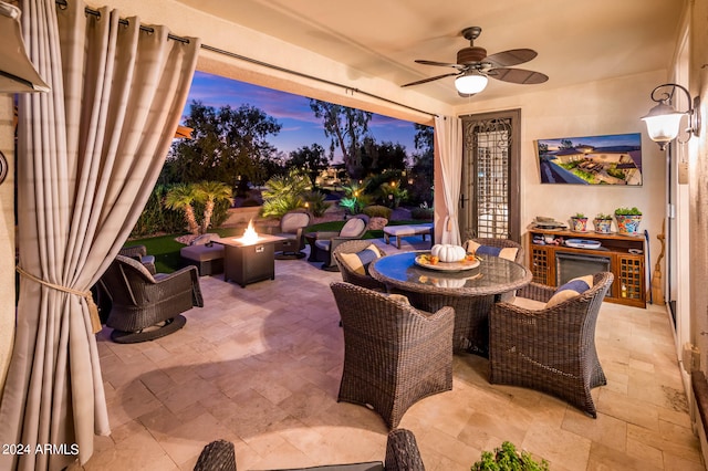 view of patio featuring ceiling fan and a fire pit